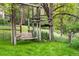 Backyard featuring green grass, mature trees, wooden playground creating a scenic, and fun outdoor space at 6686 E Jamison Ave, Centennial, CO 80112