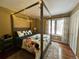 Cozy bedroom with a rustic four-poster bed, soft rug, and bright natural light at 85 S Sherwood Gln, Monument, CO 80132