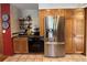 Modern kitchen featuring stainless steel refrigerator and wooden cabinets with tiled floors at 85 S Sherwood Gln, Monument, CO 80132