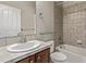 Cozy bathroom featuring a tile shower-tub combo, wooden vanity, and a bright white sink at 8802 E 148Th Ln, Thornton, CO 80602