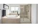 Bright bathroom featuring a tub, shower and window overlooking a green landscape at 8802 E 148Th Ln, Thornton, CO 80602