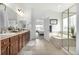 Bathroom featuring a soaking tub, walk-in shower, double vanity, and tasteful decor at 8802 E 148Th Ln, Thornton, CO 80602