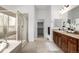 Spacious bathroom with a soaking tub, glass shower, and dual vanity, offering luxury at 8802 E 148Th Ln, Thornton, CO 80602