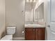 Traditional bathroom with a wooden vanity, framed mirror and a white toilet at 8802 E 148Th Ln, Thornton, CO 80602