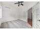 Empty bedroom featuring neutral carpet, ceiling fan, and view into adjoining area at 8802 E 148Th Ln, Thornton, CO 80602