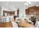 Eat-in kitchen area features wood table, kitchen with stainless appliances and wood cabinetry at 8802 E 148Th Ln, Thornton, CO 80602