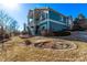 Blue house exterior with tiered landscaping, lawn, and mature shrubs at 8802 E 148Th Ln, Thornton, CO 80602