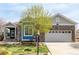 Charming single-Gathering home featuring a stone facade, attached two-car garage, and manicured front yard at 8802 E 148Th Ln, Thornton, CO 80602
