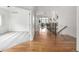 Open hallway view with hardwood flooring, leading to carpeted room and showcasing the home's bright, airy design at 8802 E 148Th Ln, Thornton, CO 80602