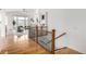 Light-filled hallway leads to living area with fireplace, showcasing hardwood floors and wrought iron staircase at 8802 E 148Th Ln, Thornton, CO 80602