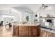 Bright kitchen features a center island with granite countertop, hardwood floors, and a view of an adjacent dining area at 8802 E 148Th Ln, Thornton, CO 80602