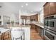 Bright kitchen with island and stainless appliances and hardwood floors at 8802 E 148Th Ln, Thornton, CO 80602