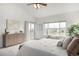 A bright main bedroom featuring a ceiling fan, a dresser, and a sliding glass door for access to an outdoor space at 8802 E 148Th Ln, Thornton, CO 80602