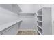 Bright walk-in closet featuring white shelving and ample storage for organized wardrobe solutions at 8802 E 148Th Ln, Thornton, CO 80602