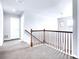 Upstairs hallway features neutral walls, wood banister, and stylish light fixture at 22441 E Chenango Dr, Aurora, CO 80015