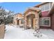 Front view of townhome showcasing snowy landscaping and stone details at 8551 Gold Peak Dr # B, Highlands Ranch, CO 80130