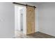 Bedroom featuring a stylish wooden barn door leading to a closet at 3281 S Estes St, Lakewood, CO 80227