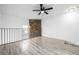 Bright bonus room with wood-look floors, stone accent wall, and a modern ceiling fan at 3281 S Estes St, Lakewood, CO 80227