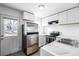 Modern kitchen with stainless steel appliances, white cabinets, marble countertops, and natural light from the backyard at 3281 S Estes St, Lakewood, CO 80227