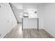 View of the kitchen, featuring modern white cabinets, stainless steel appliances, and wood-look vinyl floors at 3281 S Estes St, Lakewood, CO 80227