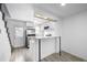 View of the kitchen, featuring modern white cabinets, stainless steel appliances, and wood-look vinyl floors at 3281 S Estes St, Lakewood, CO 80227
