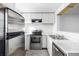 View of the kitchen, featuring stainless steel appliances and modern white cabinets and marble countertops at 3281 S Estes St, Lakewood, CO 80227