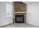 Close up of the stone fireplace in the living room with hardwood floors and a bright window to the backyard at 3281 S Estes St, Lakewood, CO 80227