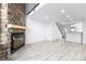 Bright living room featuring stone fireplace, hardwood floors, and access to upstairs and downstairs at 3281 S Estes St, Lakewood, CO 80227