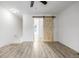 View of the loft with wood-look floors and a sliding barn door at 3281 S Estes St, Lakewood, CO 80227