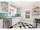 The kitchen offers bright lighting, stainless steel appliances, and black and white tiled floor at 4166 N Yates St, Denver, CO 80212