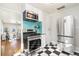 This kitchen features stainless steel appliances, black and white flooring, and a turquoise backsplash at 4166 N Yates St, Denver, CO 80212