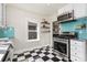 The kitchen features stainless steel appliances, black and white flooring, and a turquoise backsplash at 4166 N Yates St, Denver, CO 80212