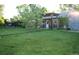 Expansive backyard featuring lush lawn, garden space, mature trees, and a charming pergola at 1047 Scranton St, Aurora, CO 80011