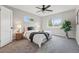 Cozy bedroom features a ceiling fan, two windows, neutral paint and carpet, and a queen sized bed at 1047 Scranton St, Aurora, CO 80011