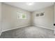 A simple, neutral-toned bedroom with two windows providing ample natural light and plush carpeting at 1047 Scranton St, Aurora, CO 80011