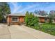 Classic brick home featuring a well-manicured lawn and a spacious driveway at 1047 Scranton St, Aurora, CO 80011