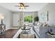 Cozy living room with hardwood floors, a ceiling fan, a large window, and neutral decor at 1047 Scranton St, Aurora, CO 80011