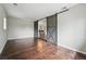 Spacious living room features hardwood floors and sliding barn doors to dining area at 1047 Scranton St, Aurora, CO 80011