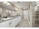 Bright bathroom featuring dual sinks, sleek countertops, and a glass-enclosed shower at 6827 Leilani Ln, Castle Rock, CO 80108