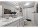Cozy bathroom with dual sinks, white vanity, decorative wall art, and bathtub with shower at 6827 Leilani Ln, Castle Rock, CO 80108