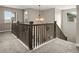 Upstairs landing featuring carpet, natural light, and dark wood railing at 6827 Leilani Ln, Castle Rock, CO 80108