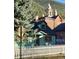Quaint turquoise home with a picket fence and views of a brick clock tower at 814 Rose St, Georgetown, CO 80444