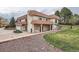 Spacious stucco house with a red tile roof, balconies, and attached garage on a landscaped lot at 7720 W Quincy Dr, Lakewood, CO 80235