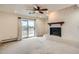 Spacious living room with a fireplace, ceiling fan, and sliding glass doors that lead to the patio at 7720 W Quincy Dr, Lakewood, CO 80235