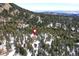 House nestled in a snowy wooded mountainside at 8919 Hillview Rd, Morrison, CO 80465