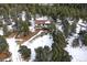 Aerial view of a house nestled in a snowy, wooded mountainside at 8919 Hillview Rd, Morrison, CO 80465