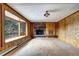 Living room with wood paneling, brick fireplace, and large window at 8919 Hillview Rd, Morrison, CO 80465