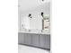 Modern bathroom with double vanity, gray cabinets, and neutral countertops at 1750 Wewatta St # 740, Denver, CO 80202