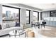 Bright open concept living space featuring city views, sleek furniture, and a modern kitchen at 1750 Wewatta St # 740, Denver, CO 80202