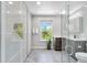 Bright, modern bathroom with glass-enclosed shower, a stylish vanity with dark wood drawers, and natural light at 2645 S Xanadu Way # D, Aurora, CO 80014
